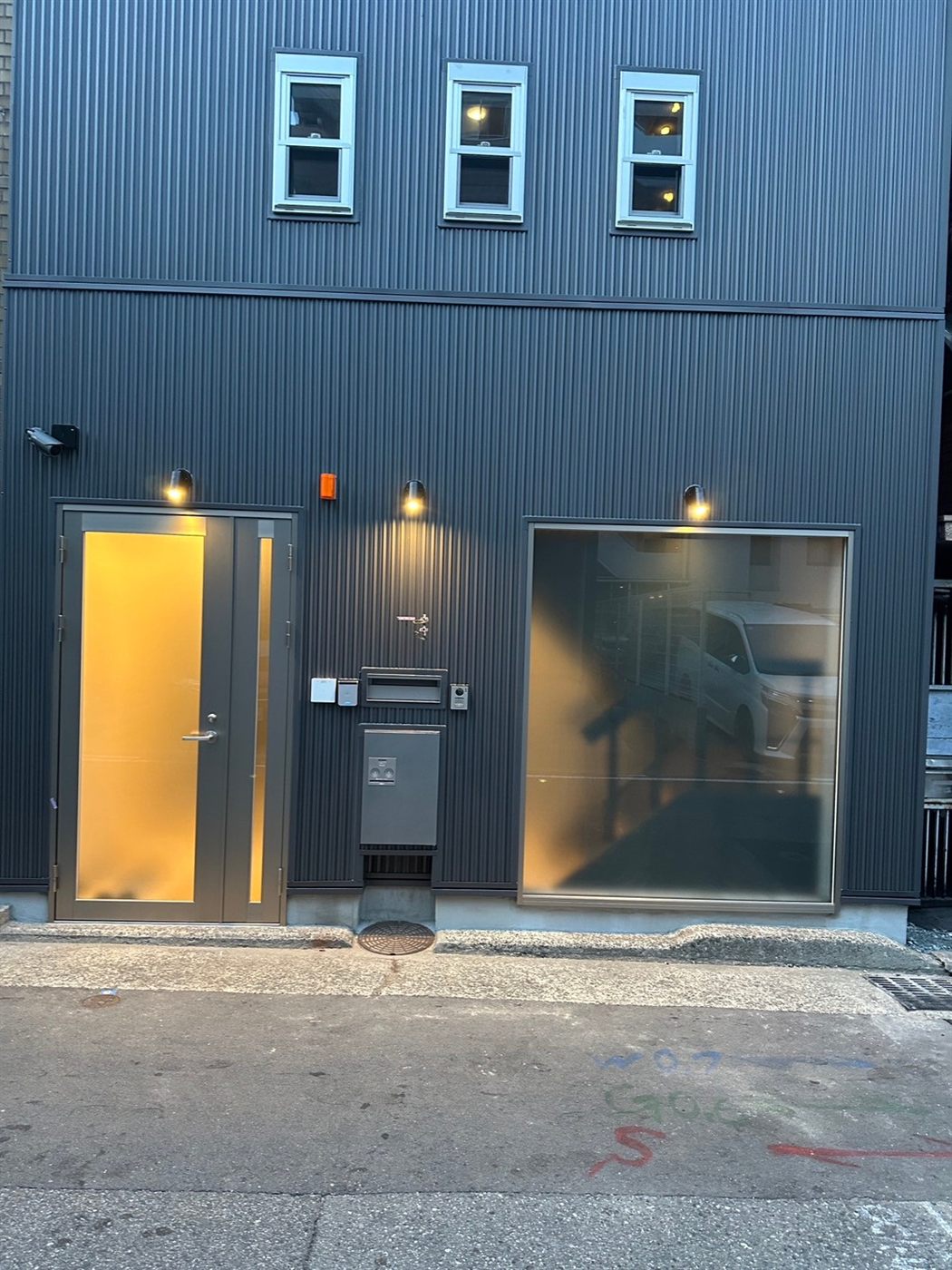 施工後：金属サイディングと照明で仕上げた事務所ビルの外観