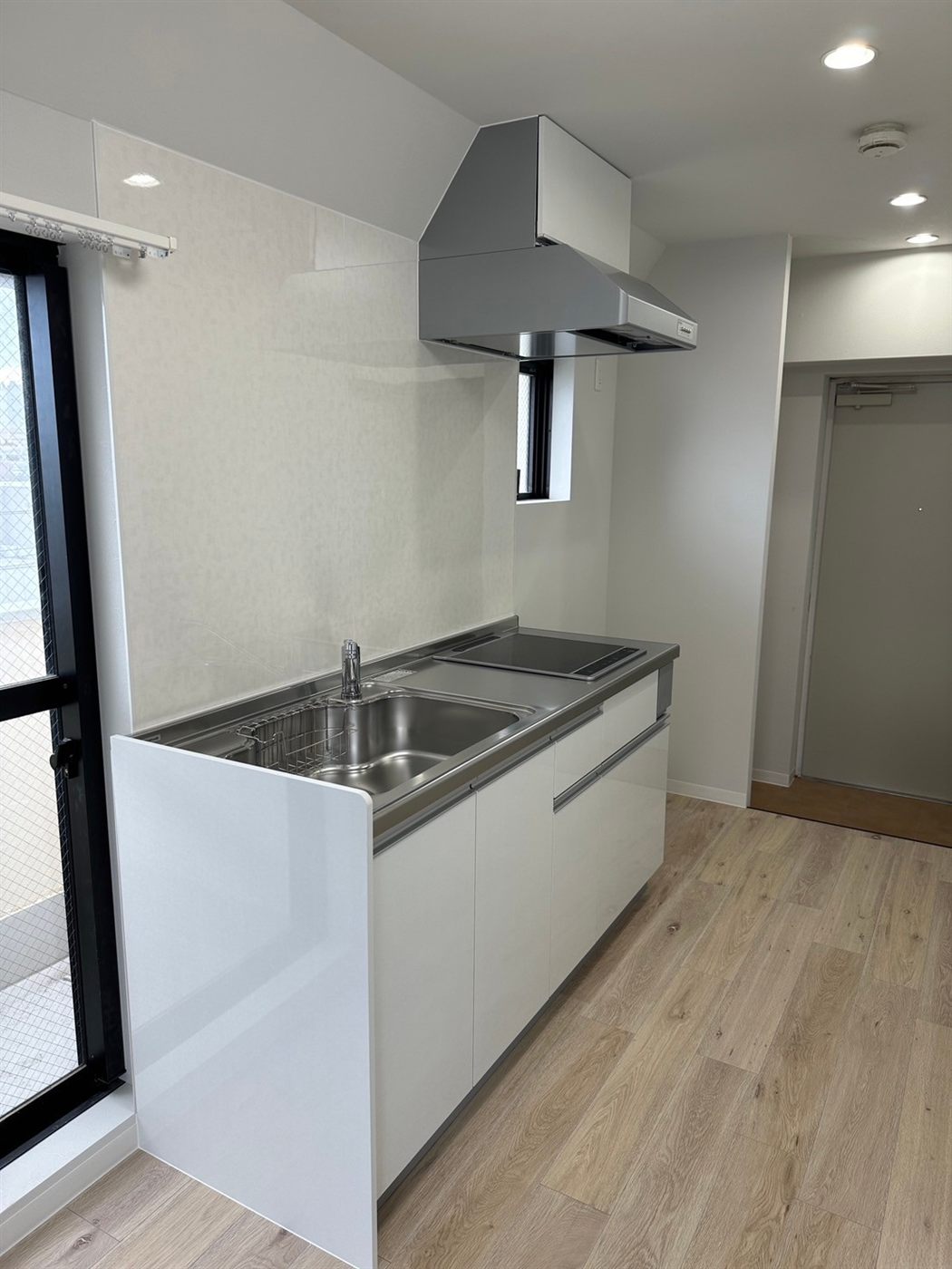 白い壁付けキッチンを新しくしたマンションの台所