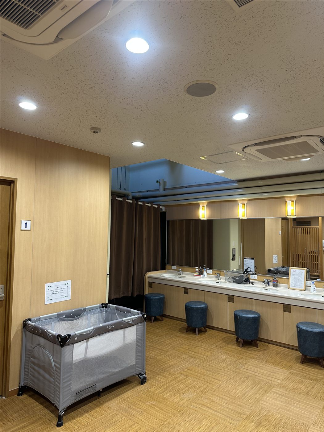木目と照明でまとめた大浴場の脱衣室
